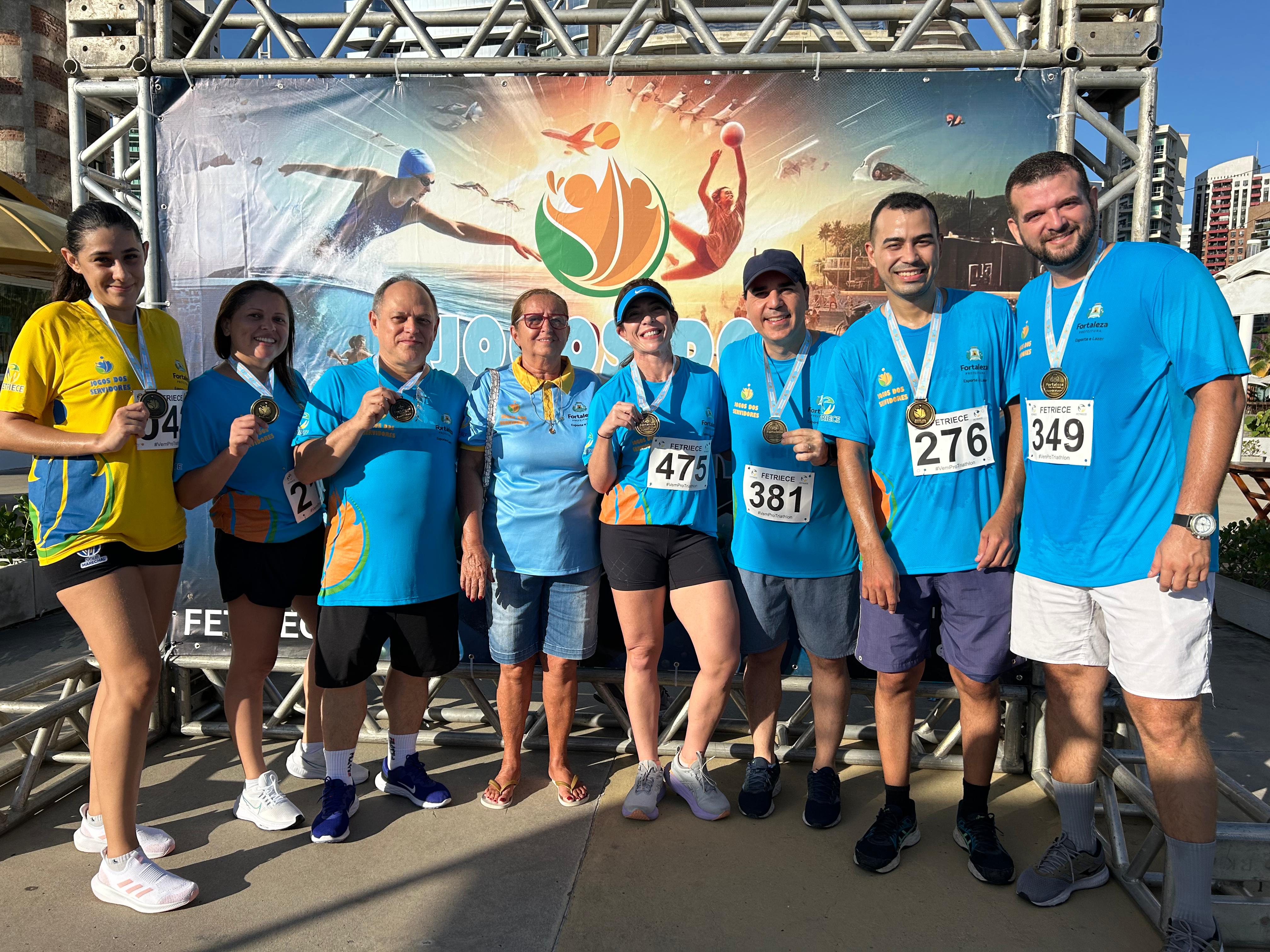 equipe segurando medalhas no pescoço